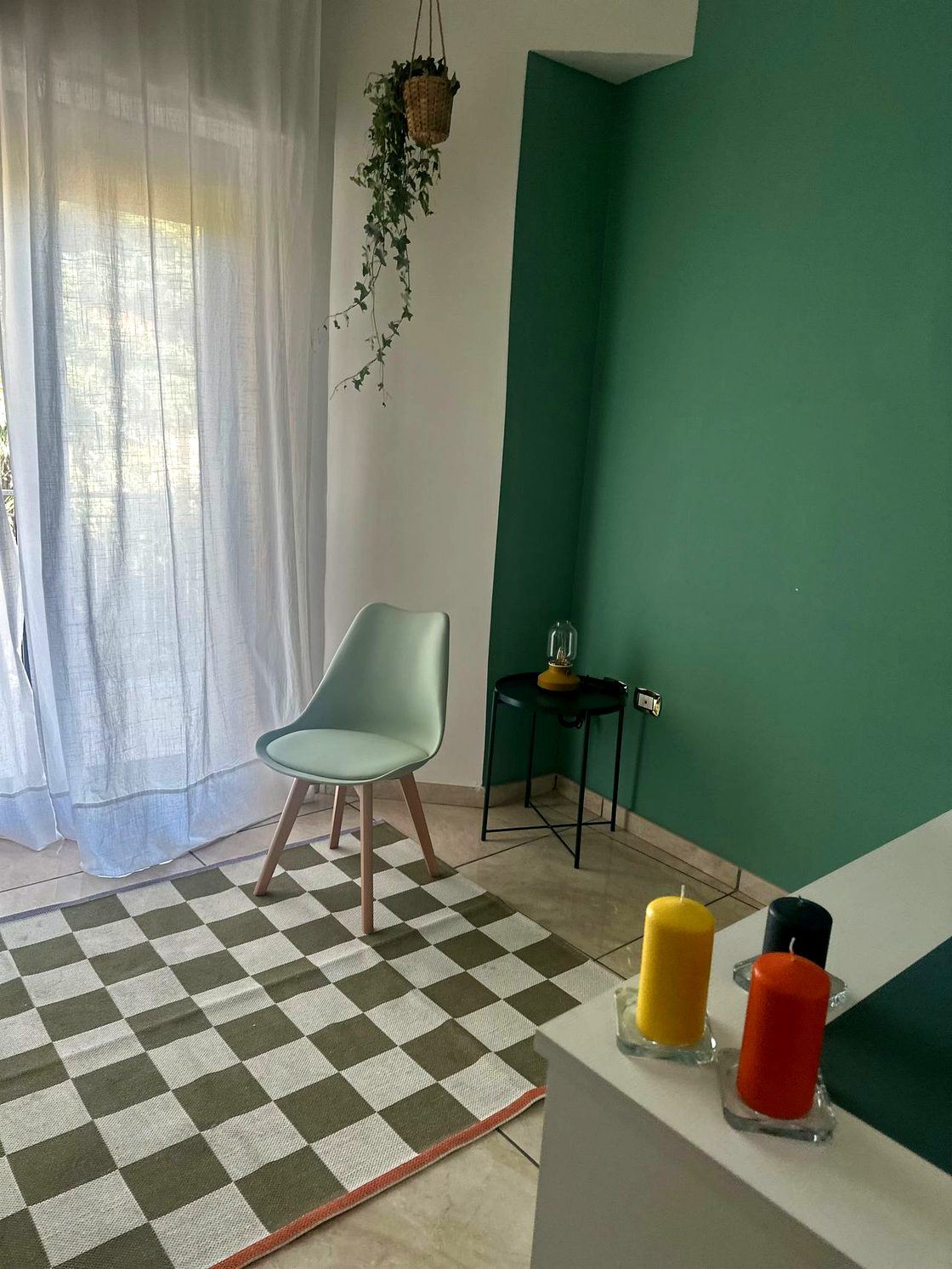 Lo studio di Marcianise: pareti verde salvia, poltroncina, pavimento a scacchi verde e candele