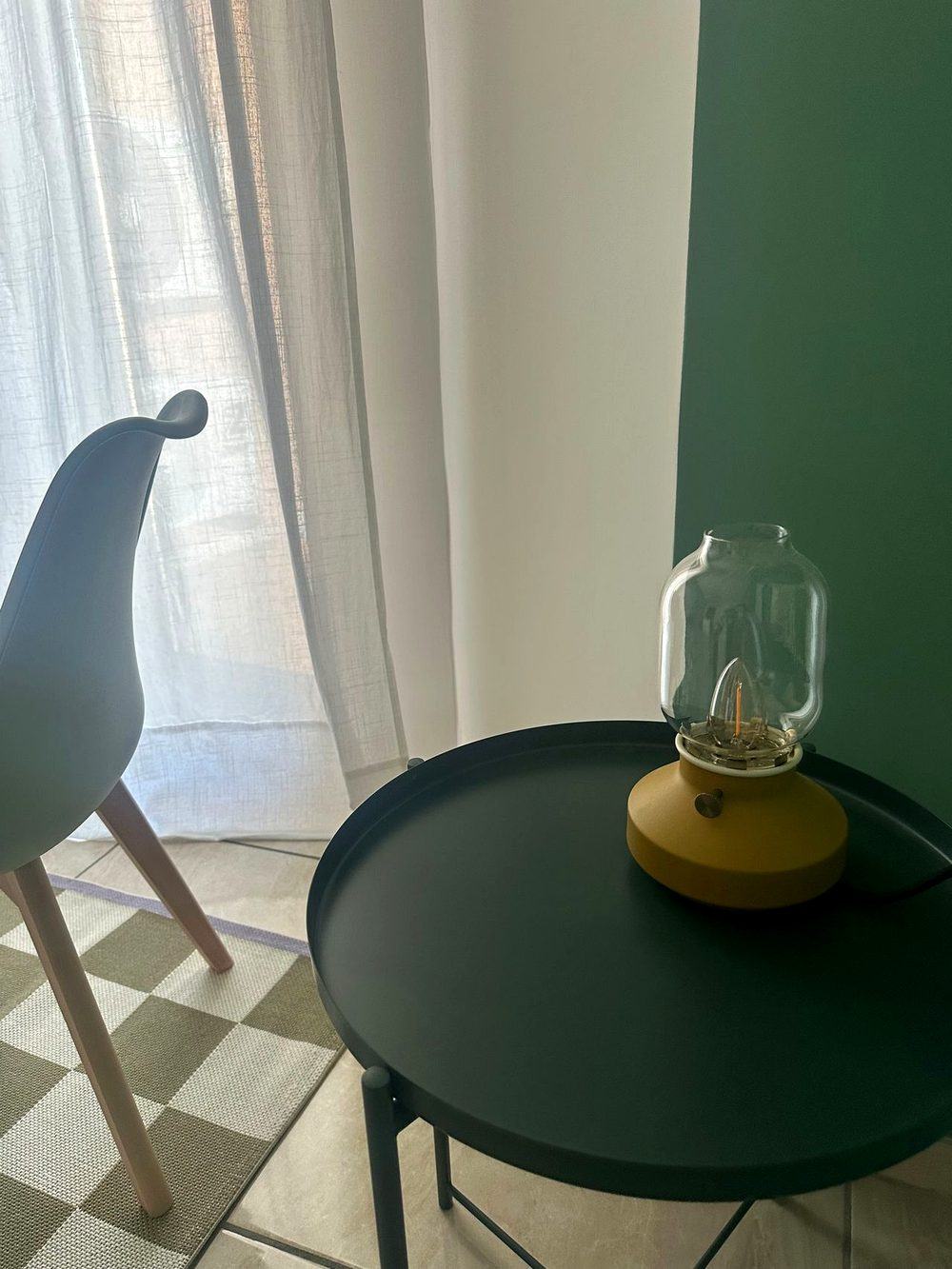 Angolo raccolto dello studio con poltroncina, tavolino e lampada calda